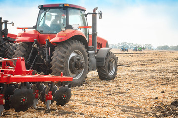 Red tractor in the field on a bright sunny day.