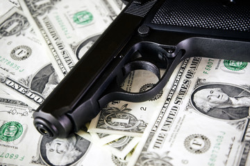 Black and chrome gun pistol and money dollars background filtered