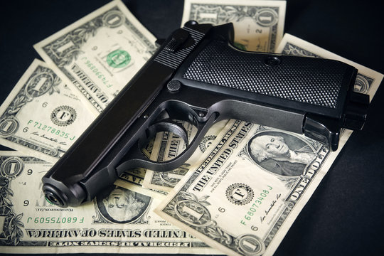 Black and chrome gun pistol and money dollars background