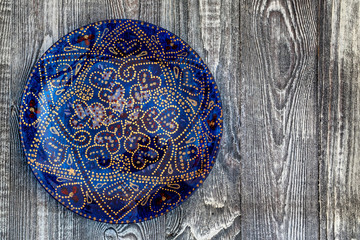 Top view blue hand-painted plate on wooden surface