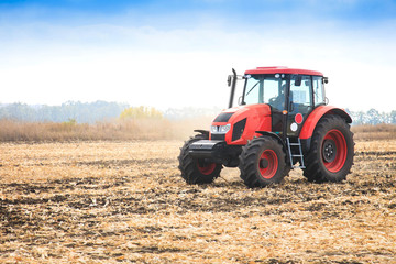 Obraz premium Modern red tractor in the field.