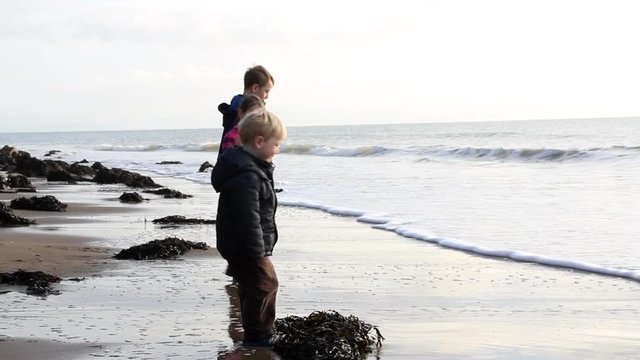 3 children playing by the sea in winter