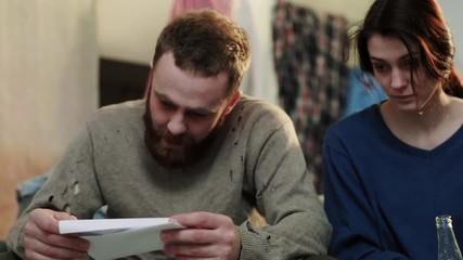 Sad young woman and man drink beer keep accounts feel stress alcoholic sit on sofa home depressed desperate drinker alcohol guy tired party woman male bottle slow motion sad close up