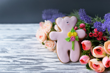 delicious gingerbread cookie teddy bear with flowers on a wooden background