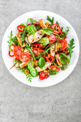 Fresh vegetable salad plate of tomatoes, spinach, pepper, arugula, chard leaves and grilled chicken breast. Fried chicken meat, fillet with salad. Healthy food. Diet dinner or lunch. Salad plate