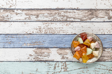 Akide (sugar) candies on old metallic plate on vintage table high angle view