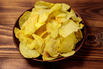 Plate of potato chips on wooden table