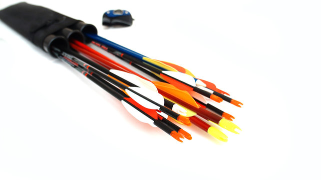 Accessories for archery. Multi-colored arrows with plastic plumage in a black quiver and a fingerstall on a white background