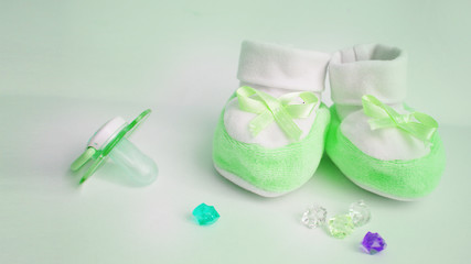 card "waiting for a miracle". bootees, multi-colored rhinestones, children's pacifier. green background