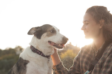 Young woman with dog on the beach in summer sunny day