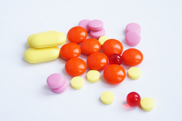 a set of orange, pink, yellow and red tablets on a white background