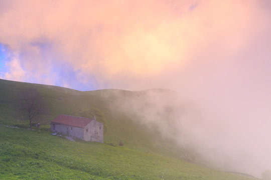 Old house with colorful clouds during sunset. Monte Linzone, Valico di Valcava(Valcava Pass), Val San Martino, Prealpi Bergamasche, Bergamo province, Lombardy, Italy.
