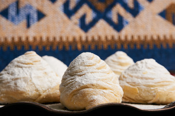 Fototapeta na wymiar Badambura powdered pastry on Novruz tray. Azerbaijan traditional pastry cookie badambura on rustic table background