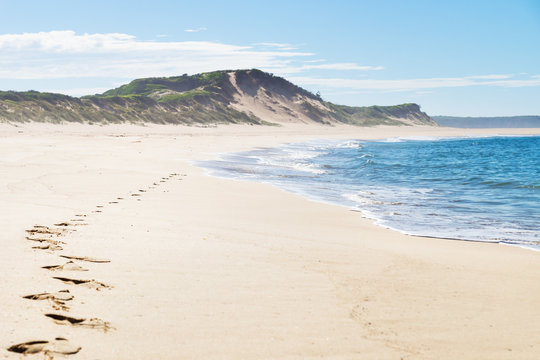 Footsteps At The Beach With Green Hills Of Peterborough At The Great Ocean Road, Victoria, Australia