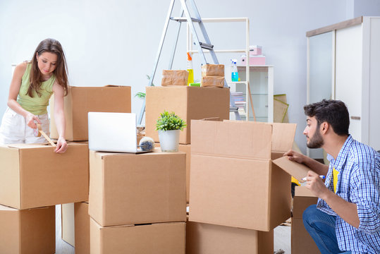 Young family unpacking at new house with boxes