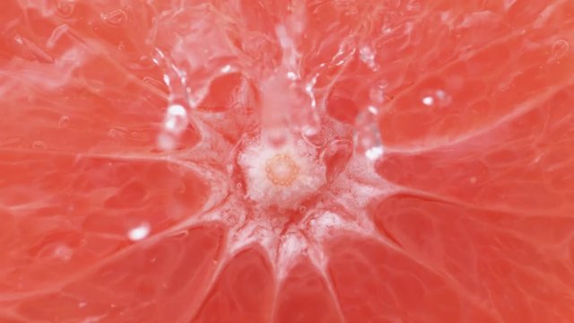 Water splash on halved pink grapefruit. Shot with high speed camera, phantom flex 4K. Slow Motion.
