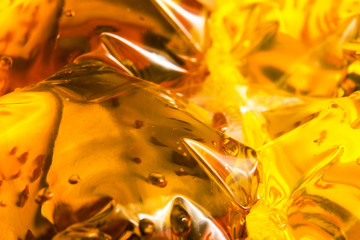 Abstract background of yellow colored liquid in a package macro