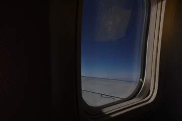 Aicraft window and sky from inside cabin economy class