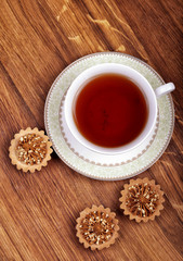 Cup of tea with cakes on a wooden background
