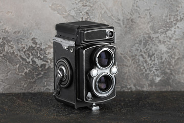 The old medium format film TLR camera on cement background.
