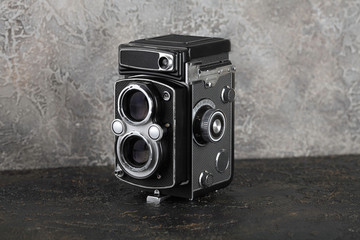 The old medium format film TLR camera on cement background.