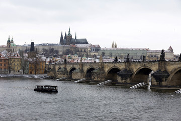 Fototapeta premium Snowy Prague Lesser Town with gothic Castle above River Vltava, Czech republic