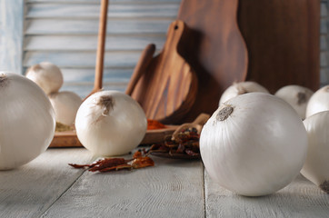 Fresh onions with dry chili peppers on wooden table