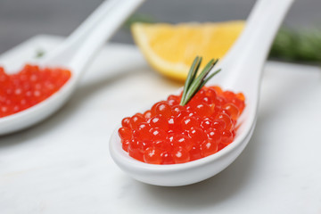 Spoon with delicious red caviar on table, closeup