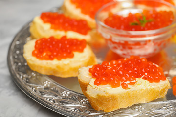 Tasty sandwiches with red caviar on vintage metal tray, closeup