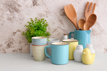 Cups and different cooking utensils on table