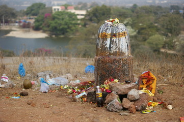 Hindu People offer prayers or do puja to stone ancient carved linga shape considered as God Shva on Maha shiva ratri ,a festival in a temple out doors