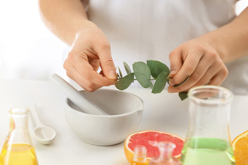 Woman preparing perfume oil at table indoors