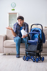Young father assembling baby pram at home