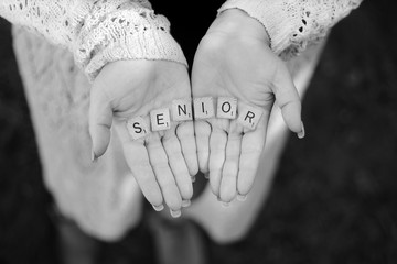 The Word senior spelled out in the hands of a young lady.