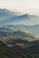 Smoky mountain landscape with mountain and light rays before sunset.