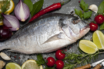Fresh Dorado fish with spices and vegetables on slate plate