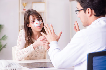 Fototapeta premium Male doctor talking to patient with nose operation surgery