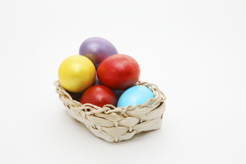 Obraz na płótnie Canvas Basket full of Easter eggs on white background with copy space for text.