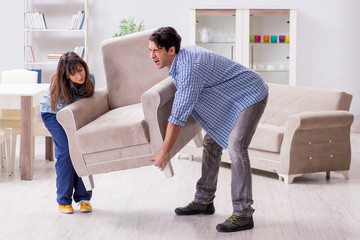 Man moving armchair in the living room