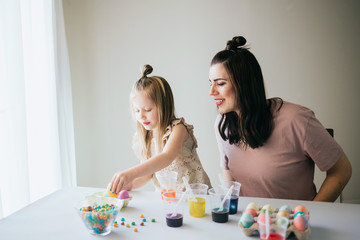 Obraz na płótnie Canvas Mother and Daughter Painting Easter Eggs together