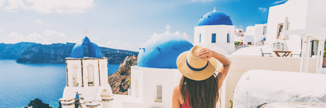 Fototapeta Summer travel tourist visiting Oia, Santorini, Europe vacation destination. Luxury holiday woman walking in city. Banner panorama.