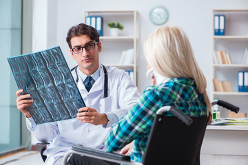 Disabled woman in wheel chair visiting man doctor