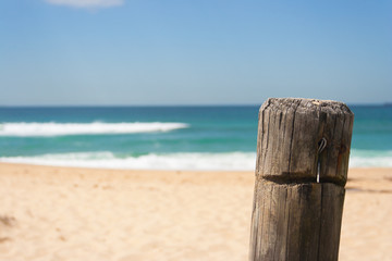 Close up of fence posts at surfing beach on a sunny day