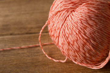 A ball of thread on the table . On the background of wooden table