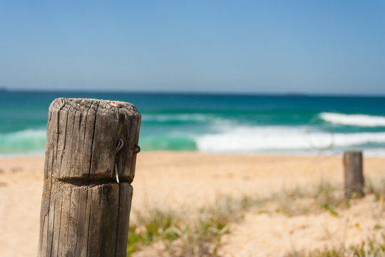 Close up of fence post at surfing beach on a sunny day