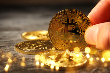 Man holding Golden Bitcoin over black background. Business concept.