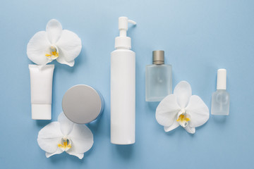 White cosmetic bottles on a blue background. flat lay