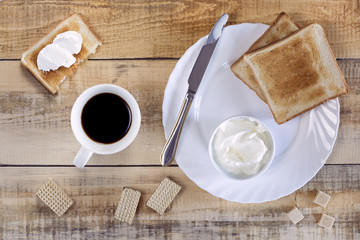 Cup of coffee and toast with butter for breakfast.Top view.