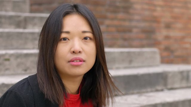 Pretty chinese woman outdoor,turning her head and looking at camera