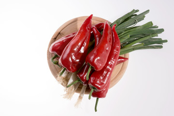 Paprika and bunch of spring onions on the wooden cutting board